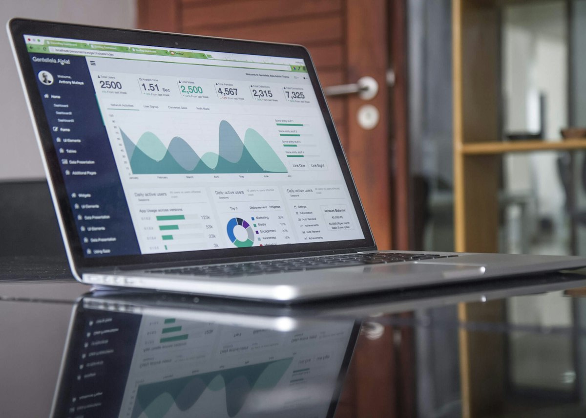 Person arbeitet an Finanzdaten auf einem Laptop